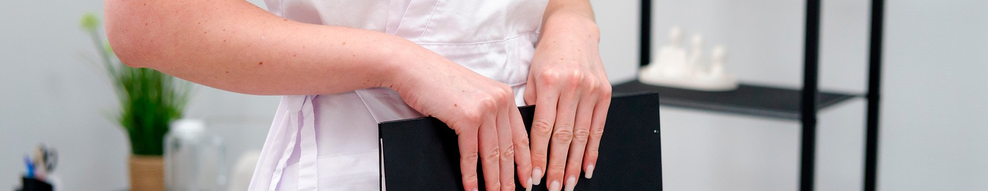 женщина доктор в белом халате и папкой в руке